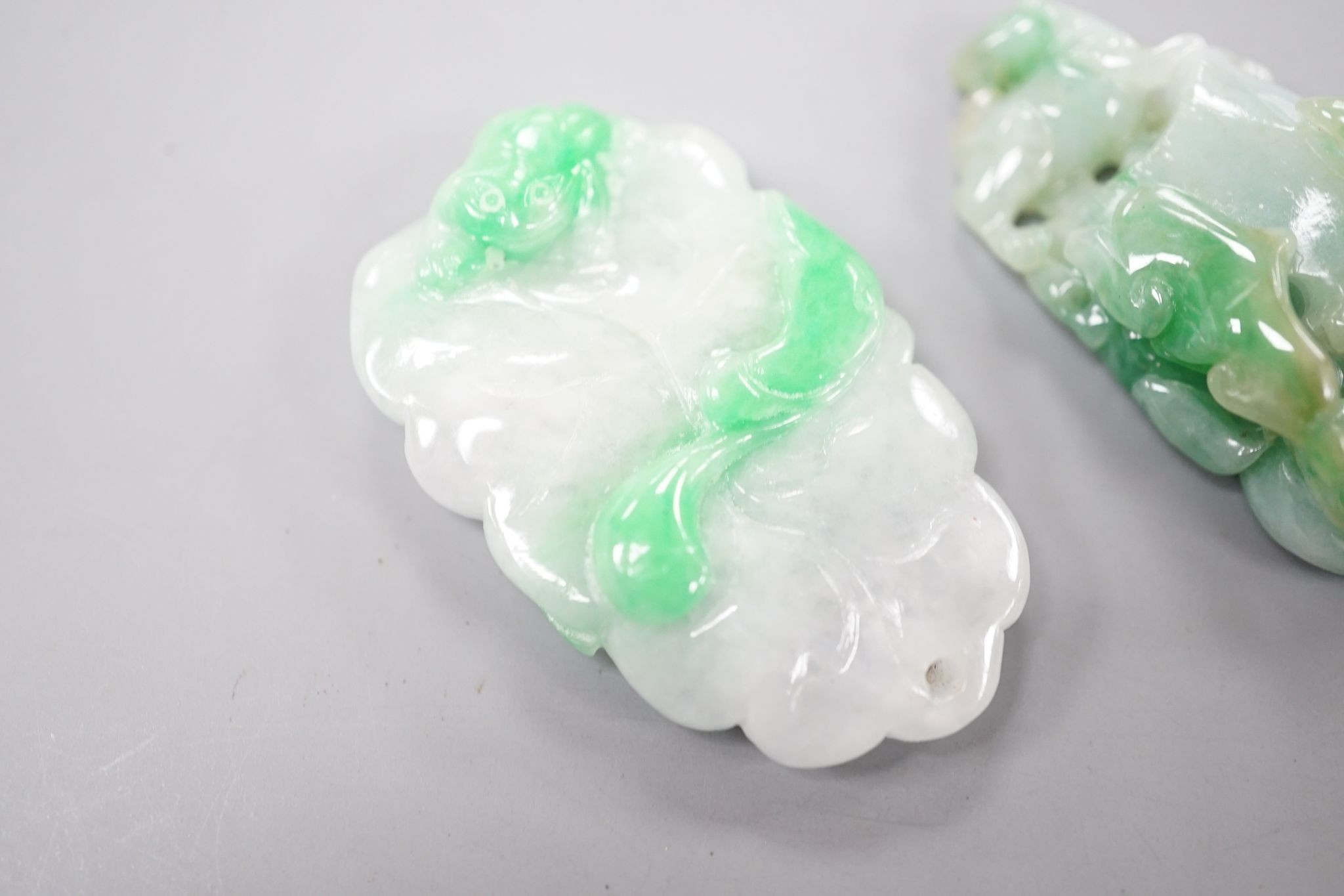 Two carved jade pendants, largest 45mm.